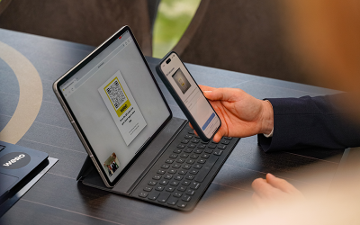 Person hält ein Smartphone vor ein Tablet mit eingeblendetem Wero-QR-Code, um eine Zahlung per Scan zu starten.